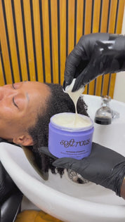 Stylist applying Soft Rows Supreme Strength Deep Conditioning Mask to freshly washed textured hair in salon